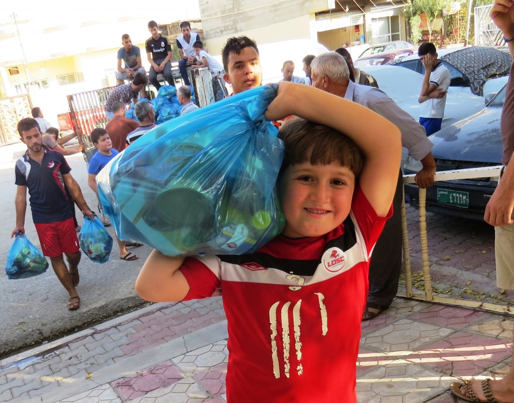 An Iraqi child with aid supplies for his family.