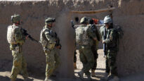 Australian and Afghan National Army soldiers work together to search the Mirabad Valley Region for weapons and Improvised Explosive Device components.