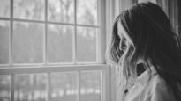 Woman looks out window. Image: Danielle MacInnes/ Unsplash